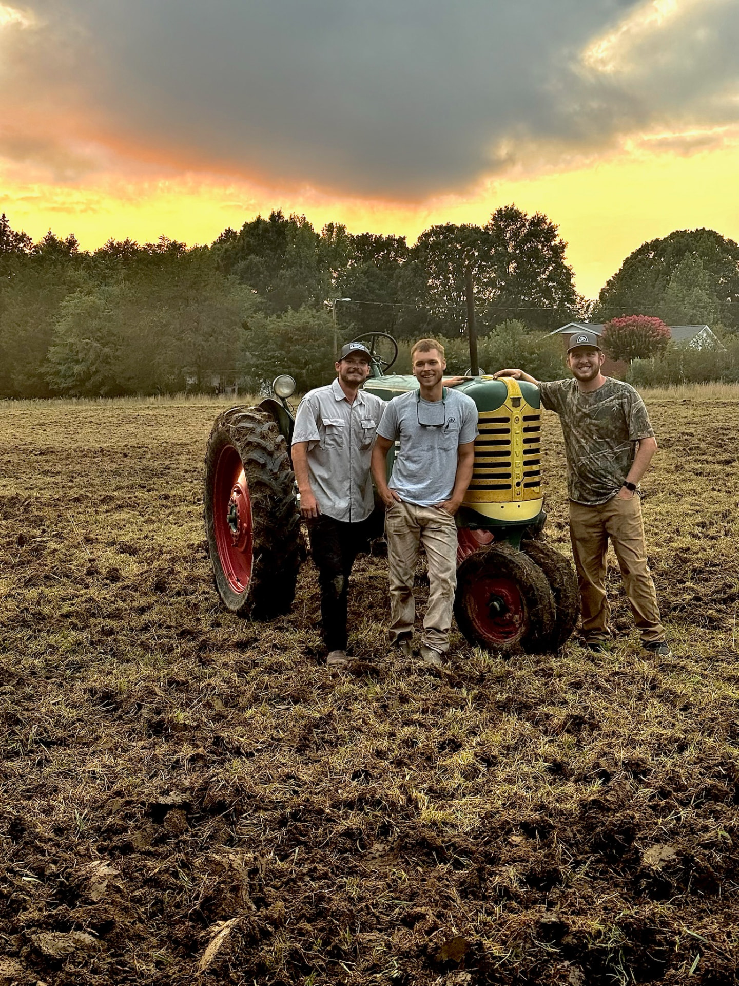 Brady, Jadon, and Viktor of 215 Farms in a plowed field at golden hour